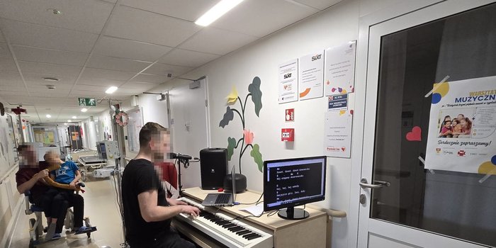 Stanowisko muzyczne na&nbsp;korytarzu oddziału, pacjenci słuchają